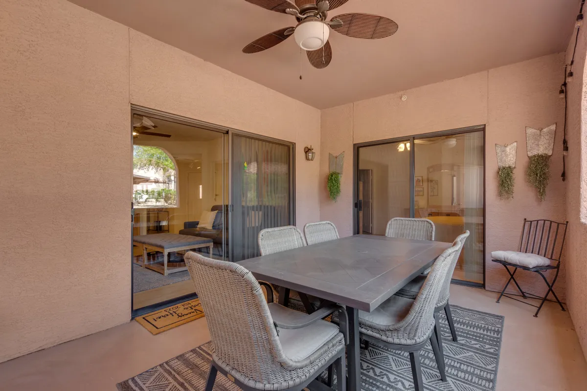 An interior view looking out from the dining area through sliding doors, hinting at access to a private deck. The space is set for al fresco dining, evoking the experience of stepping out onto a private deck for morning coffee or evening relaxation.