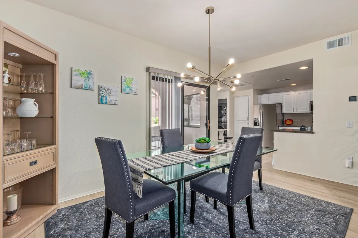 A stylish dining area featuring a modern dining table under a striking chandelier, complemented by a sideboard and tasteful wall art. The space is designed for family gatherings, entertaining guests, and fostering engaging conversations.